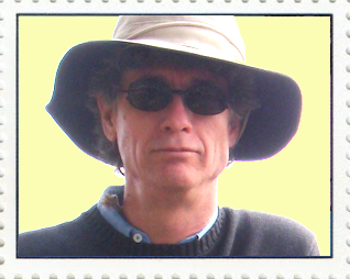 Photo of Tom Sharp, wearing a floppy hat and dark sunglasses, by Terry M. Sharp, at the rim of Haleakala
