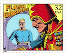 on this U.S. postage stamp, Flash Gordon, with his yellow hair, in a blue shirt, is seen in the video screen of Ming the Merciless wearing a red military suit and helmet