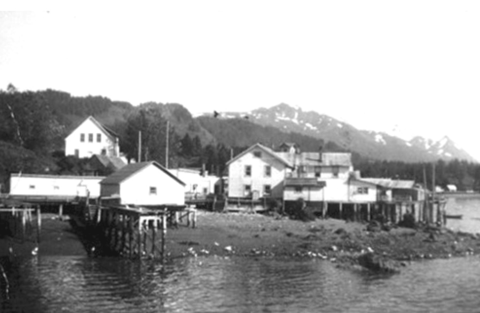 Buildings on piers, mountains behind them