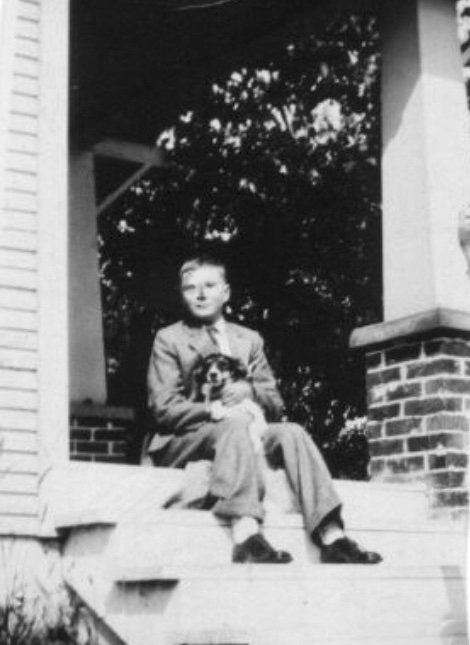 a young Bill Olssen, on front steps, holding a spaniel