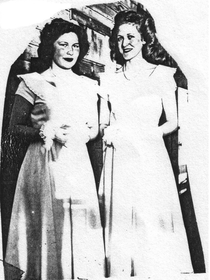 Two young women in dresses holding corsages