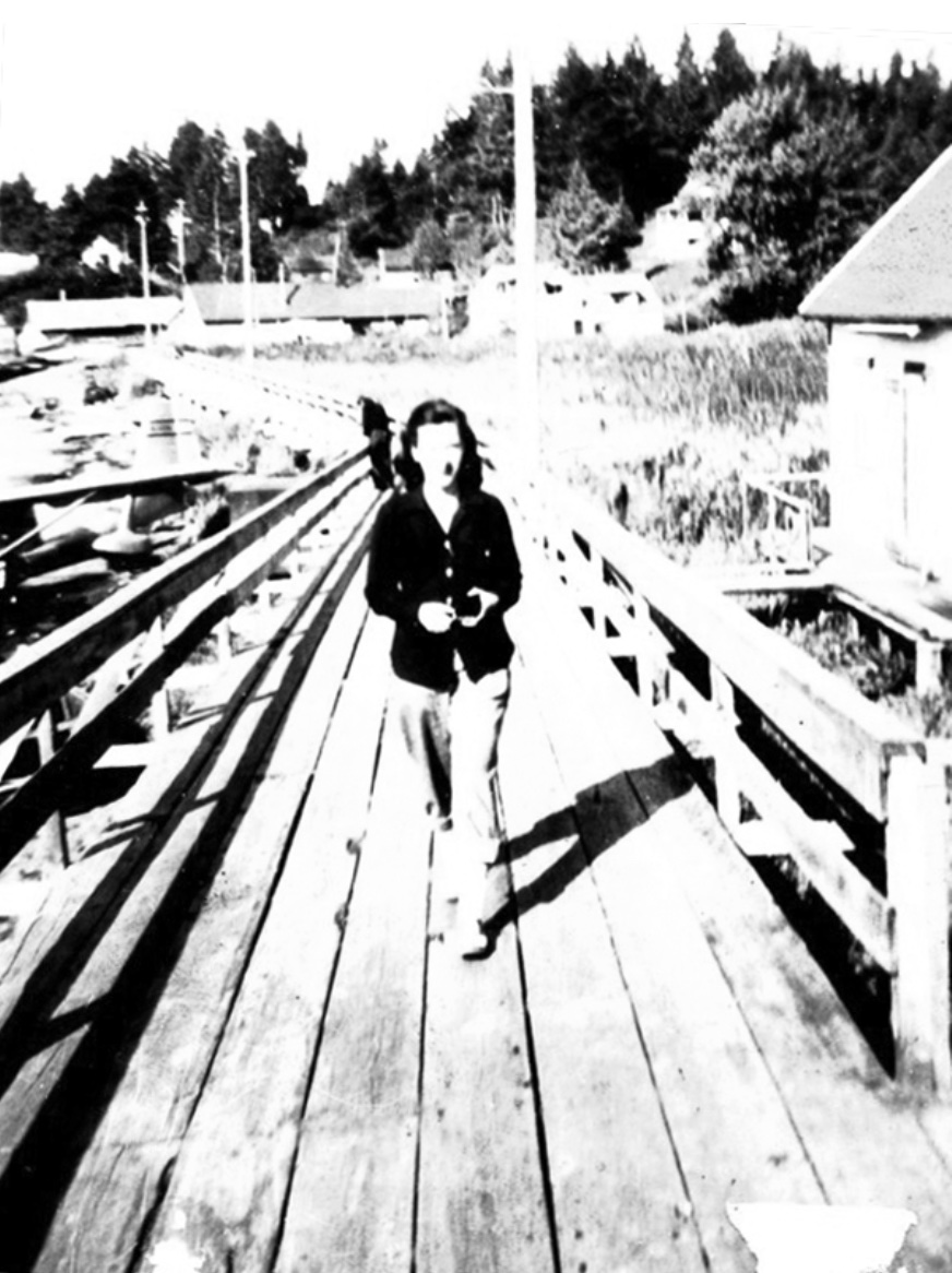 Boardwalk, about six feet wide, young woman walking toward the photographer