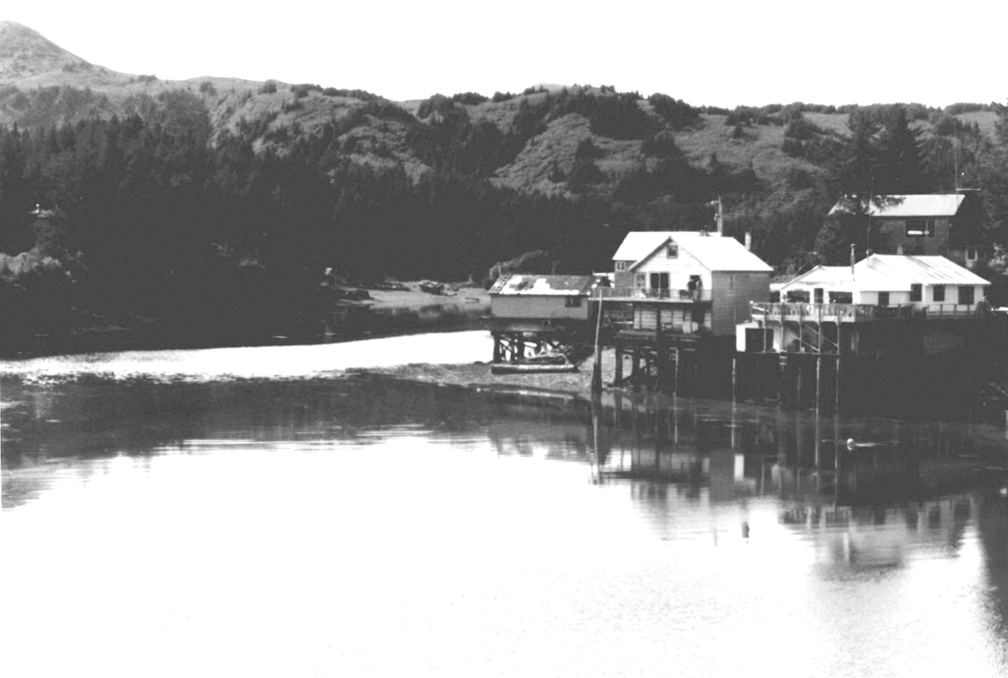 Houses and other buildings on piers above the bay and the start of the slough