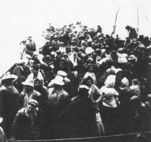 Many people standing on the deck of a boat