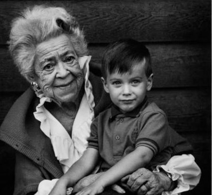 Gray-haired woman with a small boy on her lap.