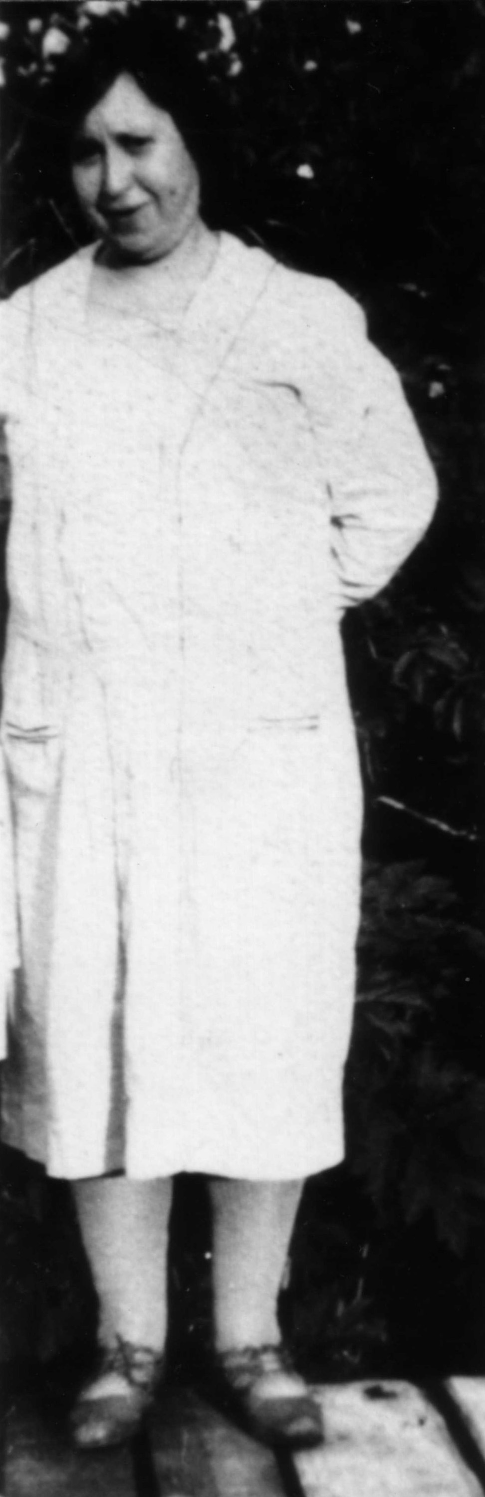 Woman standing wearing a white dress and sandals