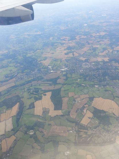 Patchwork of fields below the plane as we approach London