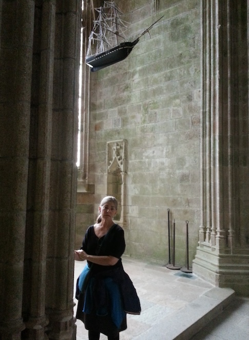 Liz under the model of a ship in a side chapel of the abbey church at Mont Saint-Michel