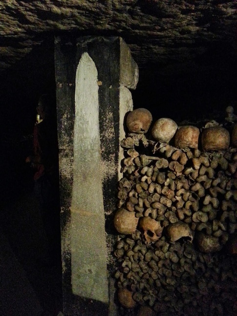 Skulls and femurs between the stones of the catacombs