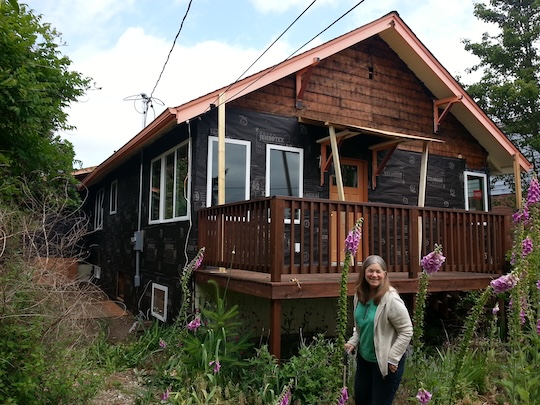 Liz poses in front of Happy House, being remodeled